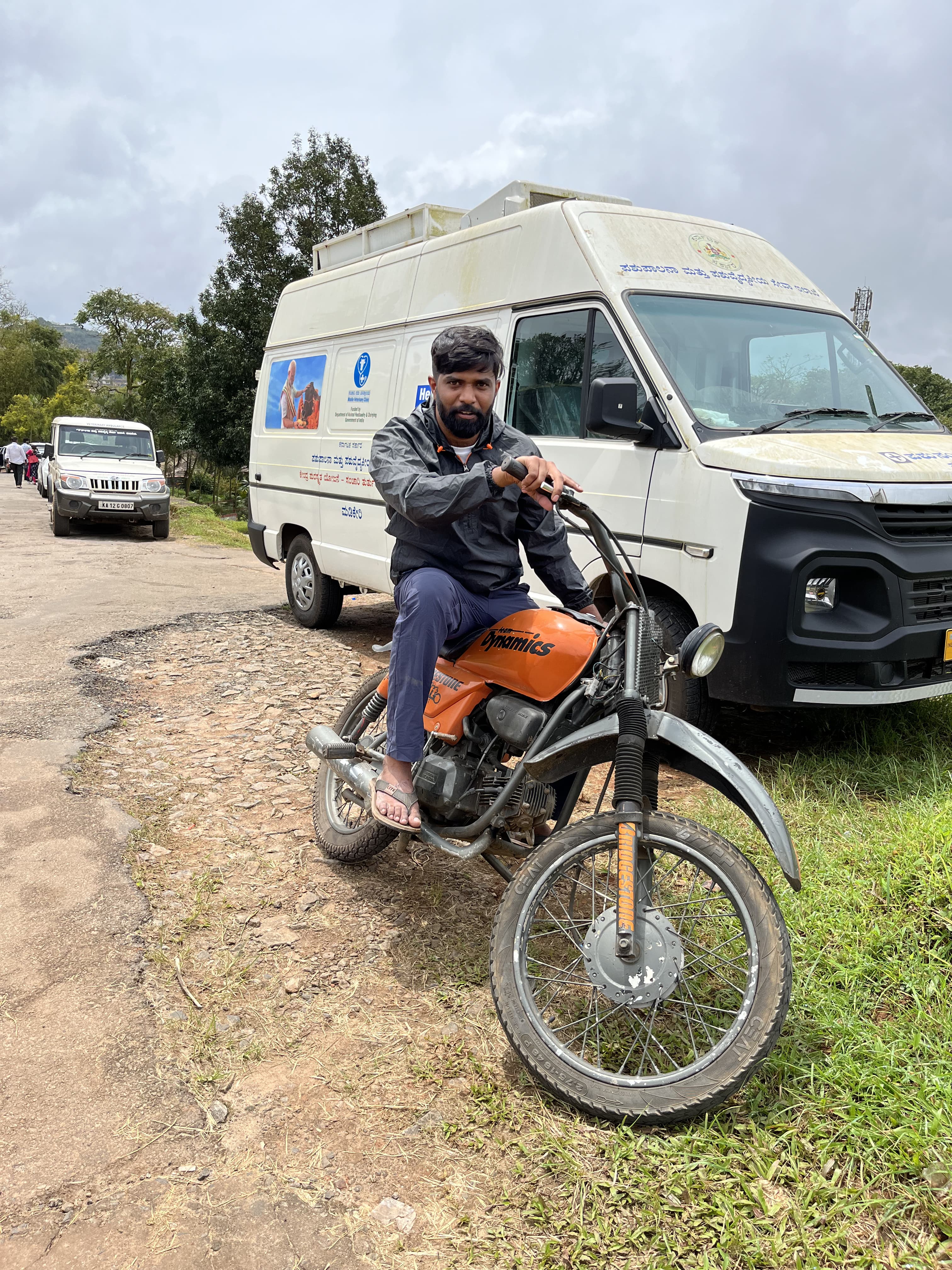 Anand on the same motorcycle, smiling.