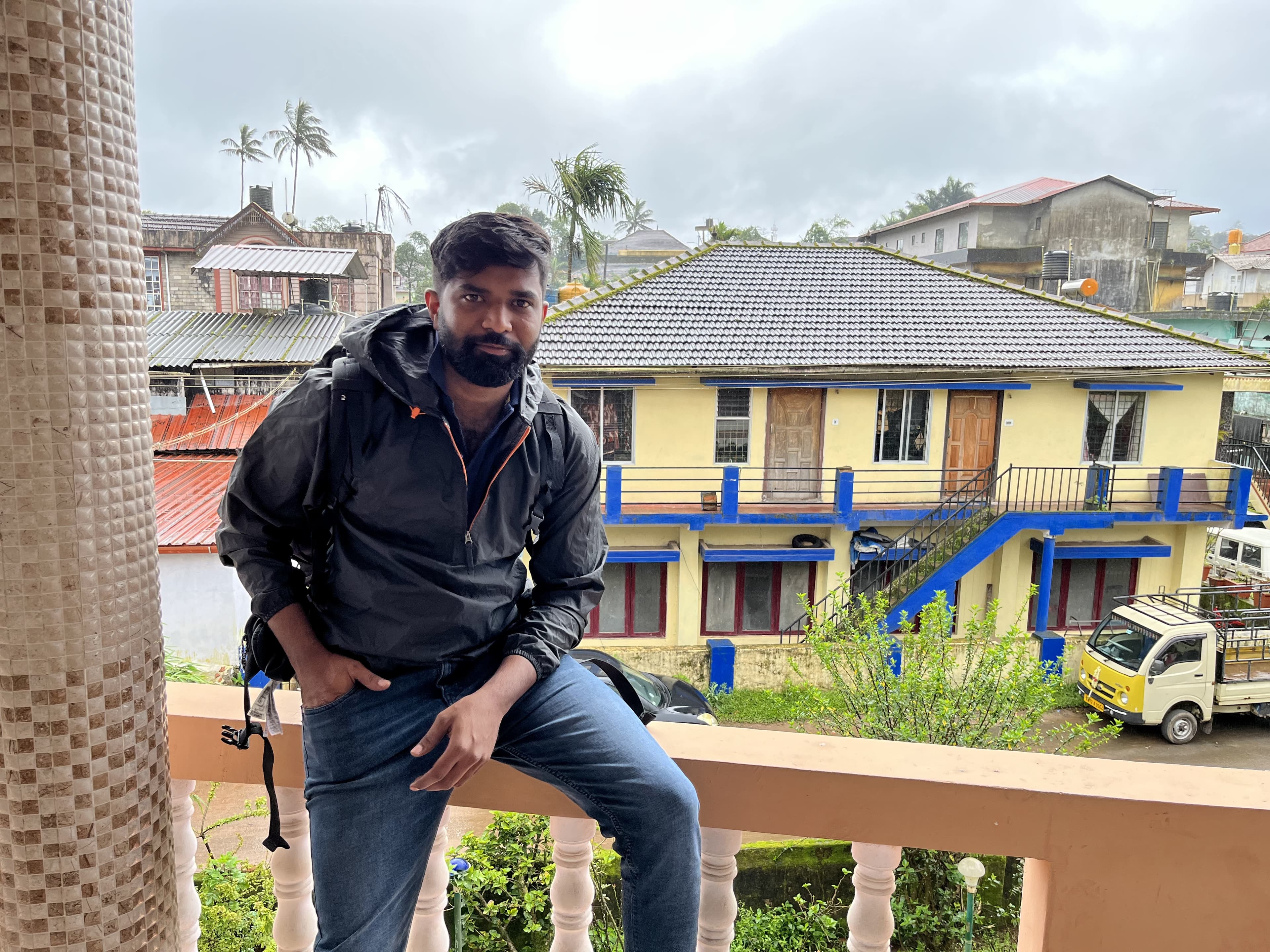 Anand sitting on a balcony railing.