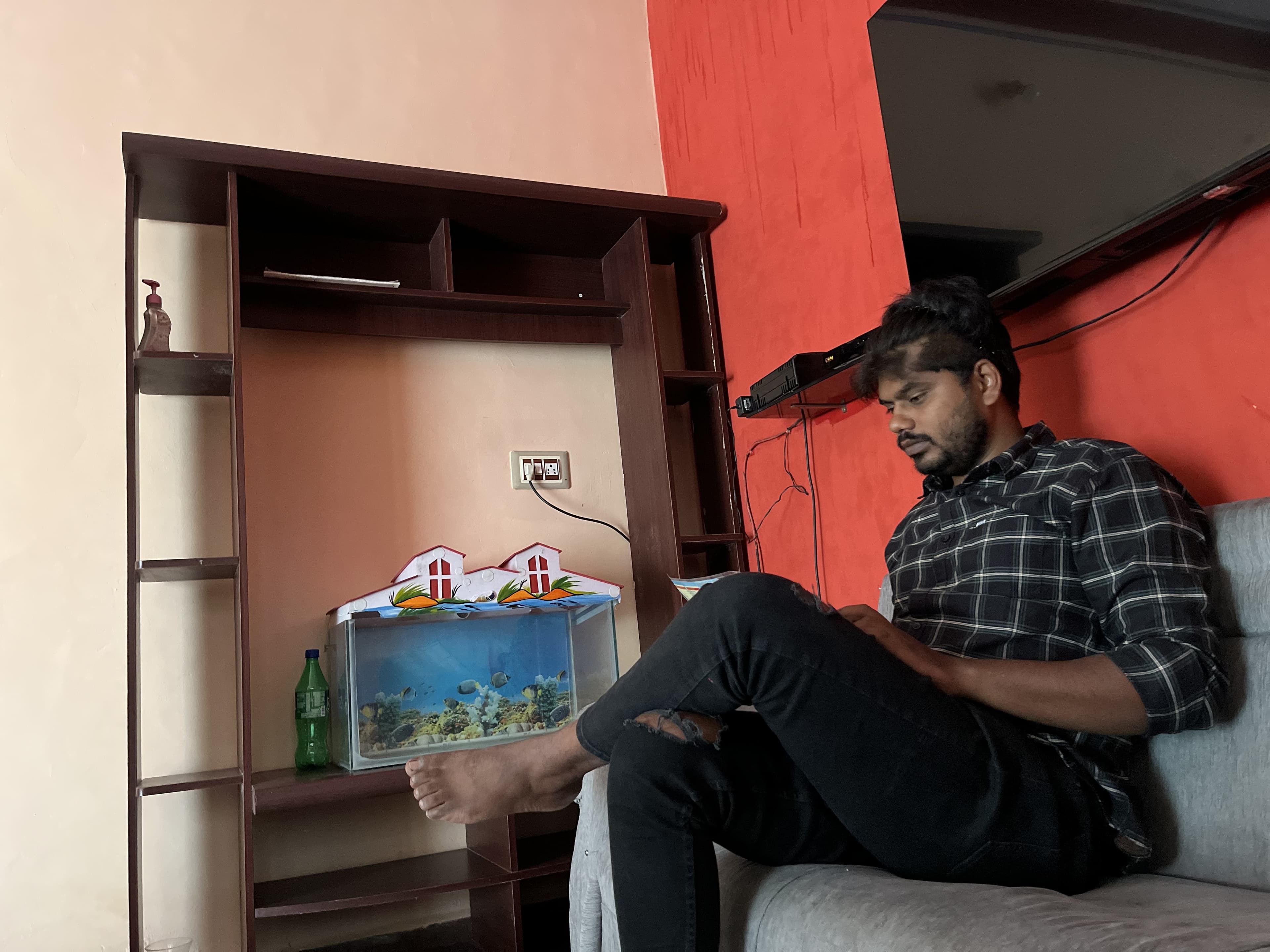 Anil sitting on a sofa, reading.