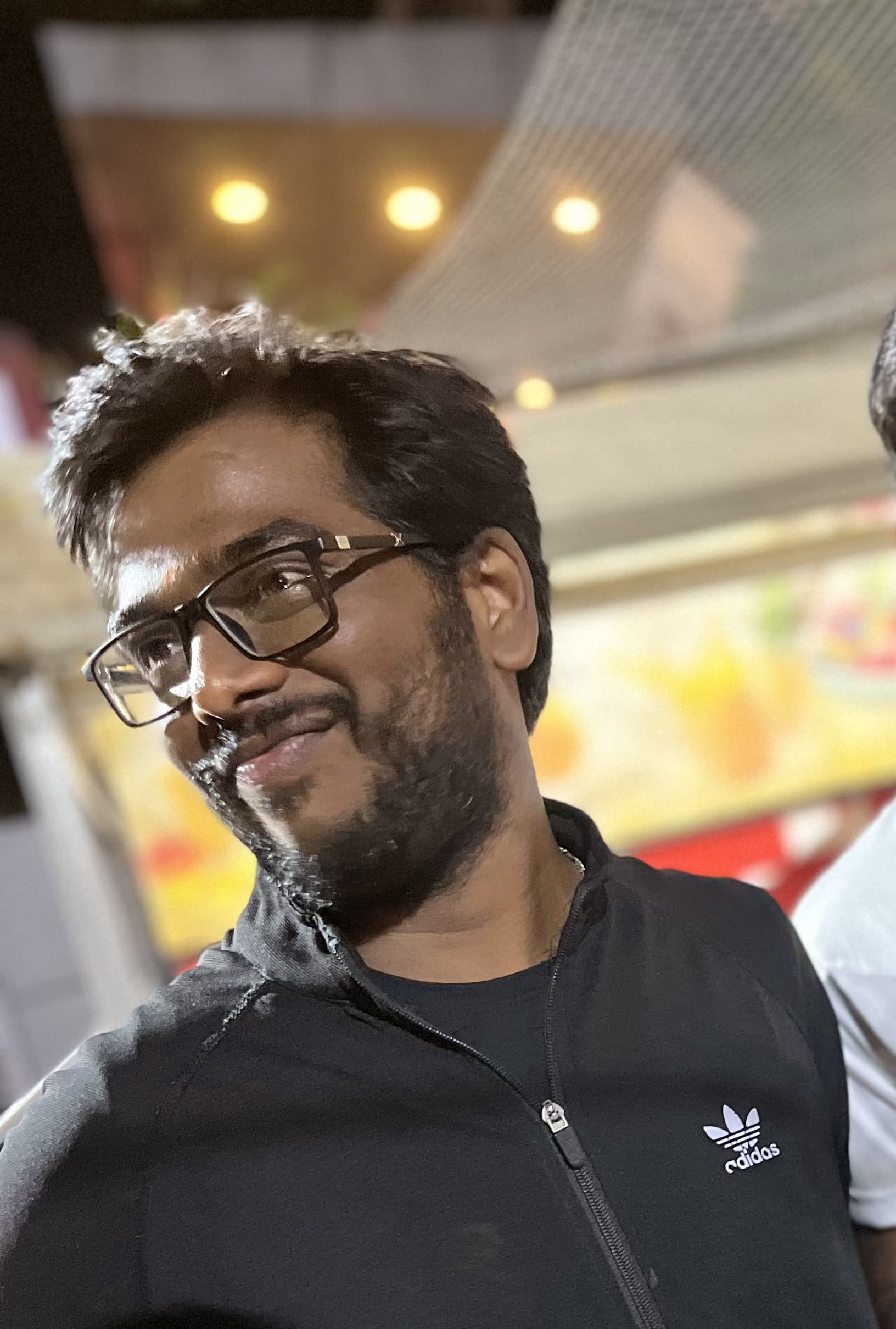 Sukumar bhai, glasses on, somewhere at night.